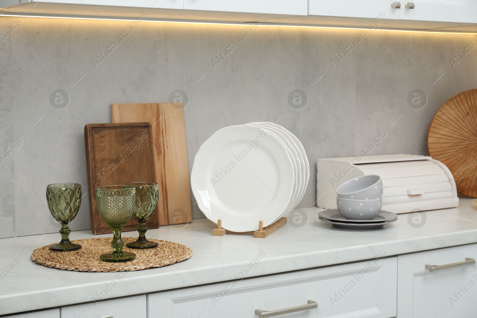 Photo of Clean dishware and glasses on countertop in kitchen