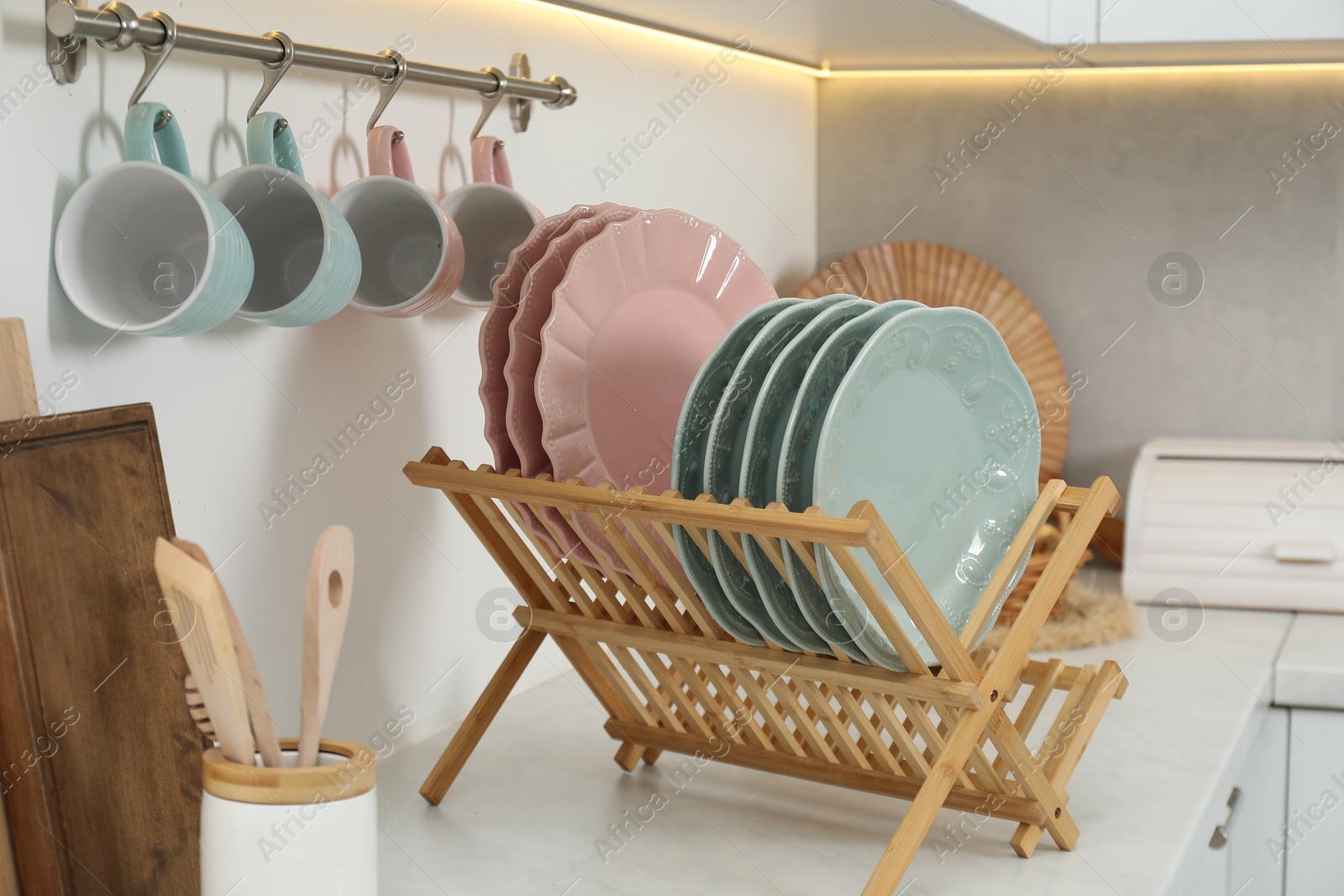 Photo of Drying rack with plates, cups and other utensils in kitchen