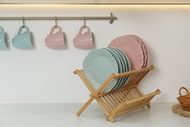 Photo of Drying rack with plates and cups in kitchen
