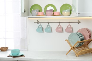Photo of Different clean dishware and cups in kitchen