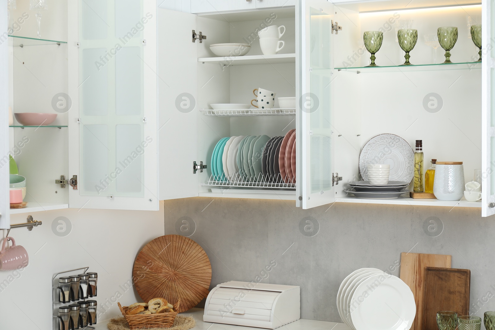 Photo of Different dishware, glasses and kitchen utensils indoors