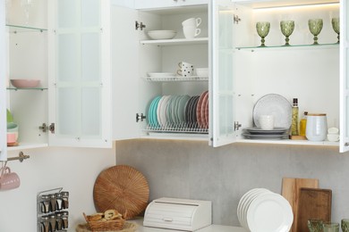 Photo of Different dishware, glasses and kitchen utensils indoors