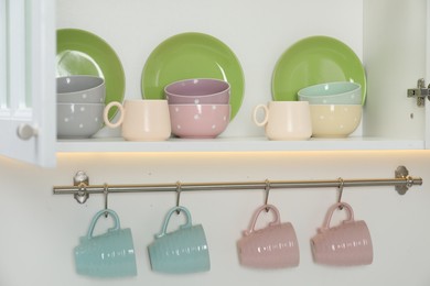 Photo of Different clean dishware and cups in kitchen
