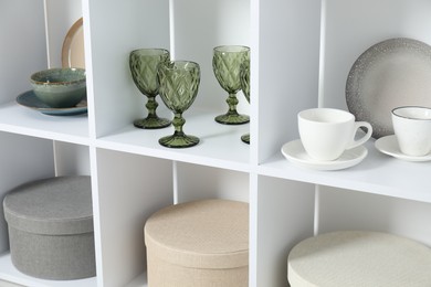 Photo of Shelving unit with different dishware, glasses and cups indoors