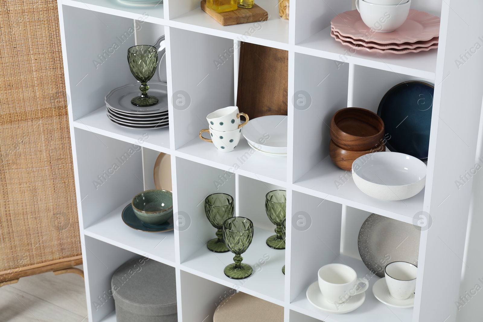 Photo of Shelving unit with different dishware, glasses and cups indoors