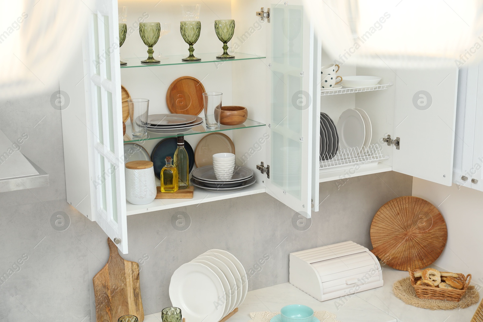 Photo of Different dishware, glasses and kitchen utensils indoors