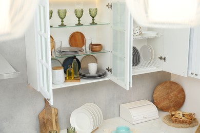 Photo of Different dishware, glasses and kitchen utensils indoors