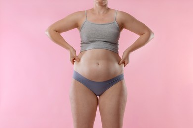 Photo of Liposuction. Woman in underwear on pink background, closeup