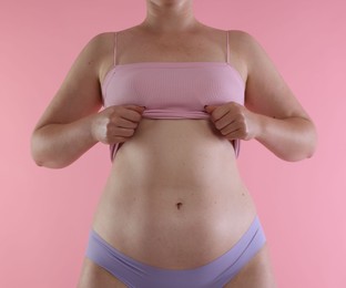 Photo of Liposuction. Woman in underwear on pink background, closeup
