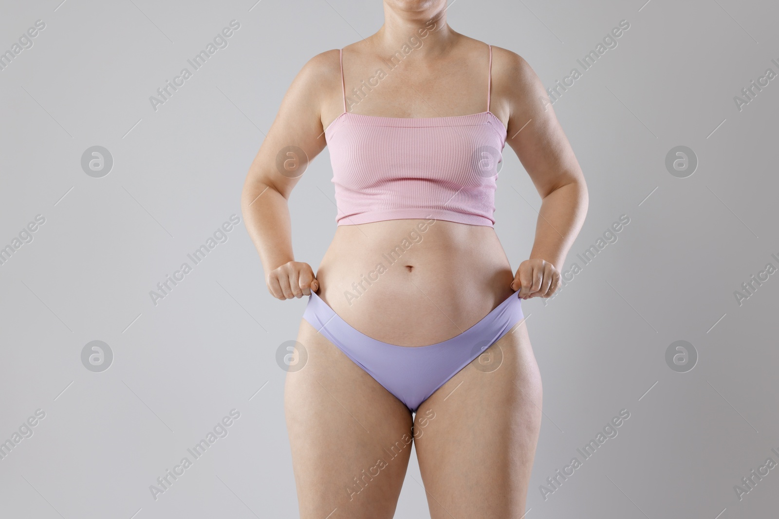 Photo of Liposuction. Woman in underwear on grey background, closeup