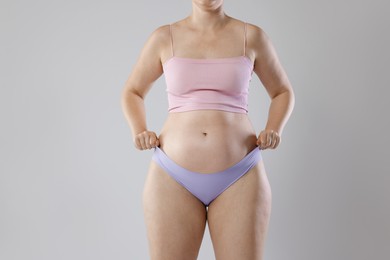 Photo of Liposuction. Woman in underwear on grey background, closeup