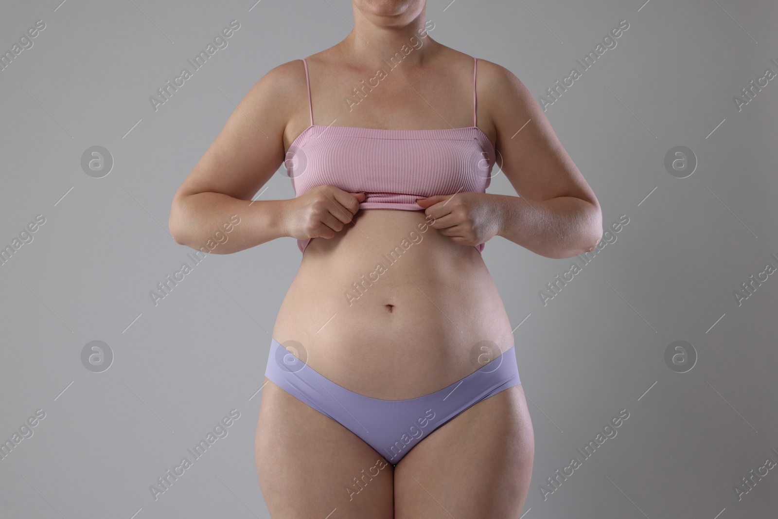 Liposuction. Woman in underwear on grey background, closeup Photo of Liposuction. Woman in underwear on grey background, closeup