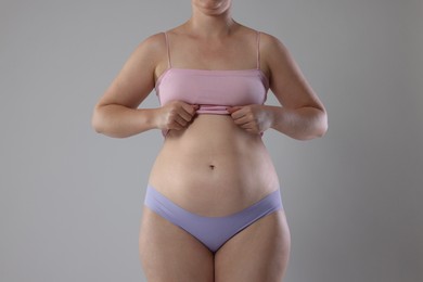 Photo of Liposuction. Woman in underwear on grey background, closeup