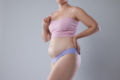Photo of Liposuction. Woman in underwear on grey background, closeup