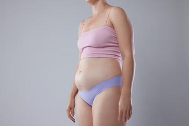 Photo of Liposuction. Woman in underwear on grey background, closeup