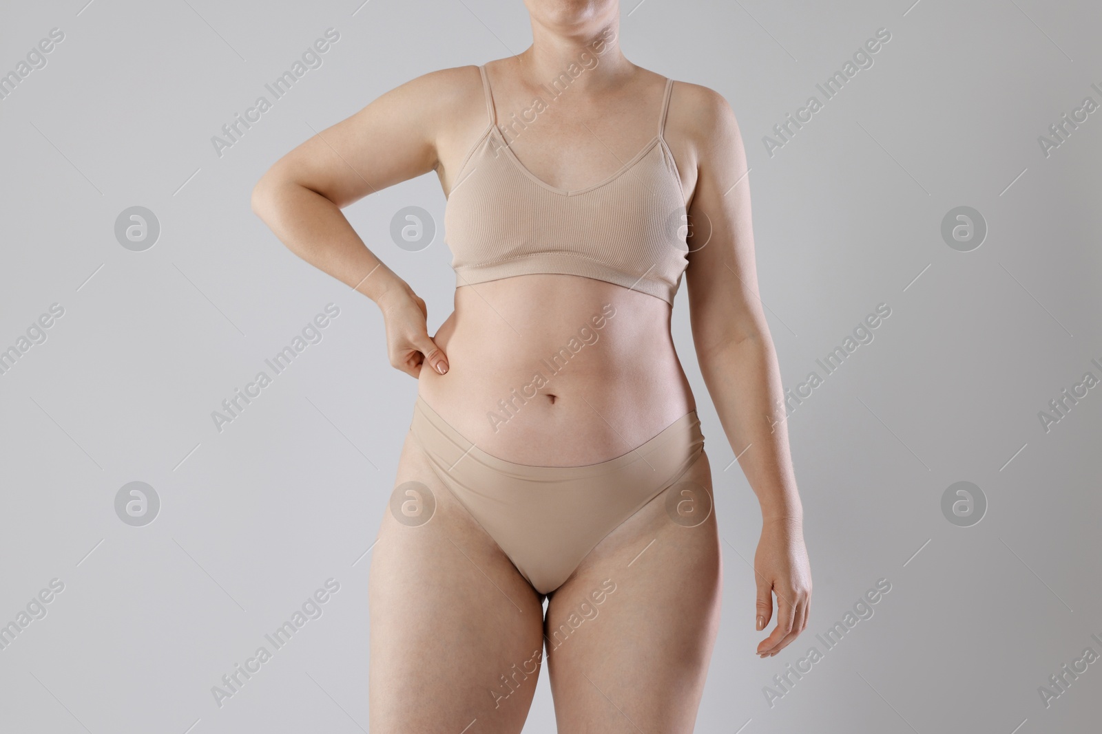 Liposuction. Woman in underwear on grey background, closeup Photo of Liposuction. Woman in underwear on grey background, closeup
