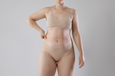 Photo of Liposuction. Woman in underwear on grey background, closeup