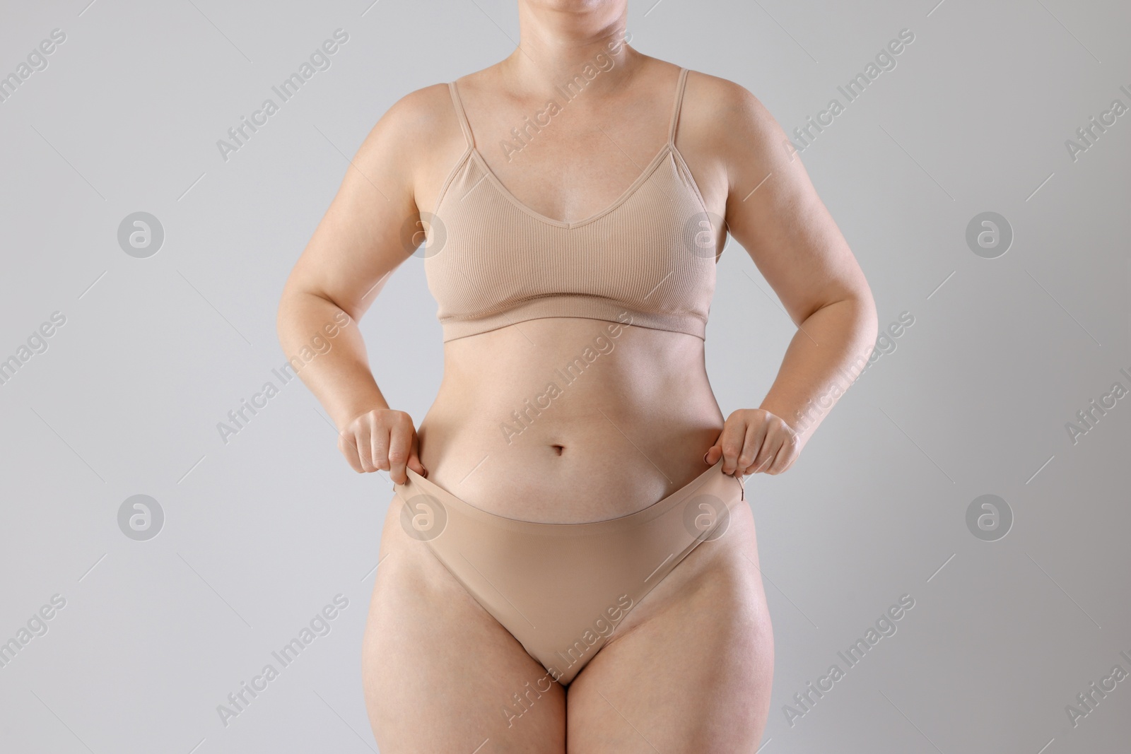 Photo of Liposuction. Woman in underwear on grey background, closeup