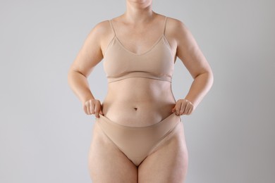 Photo of Liposuction. Woman in underwear on grey background, closeup