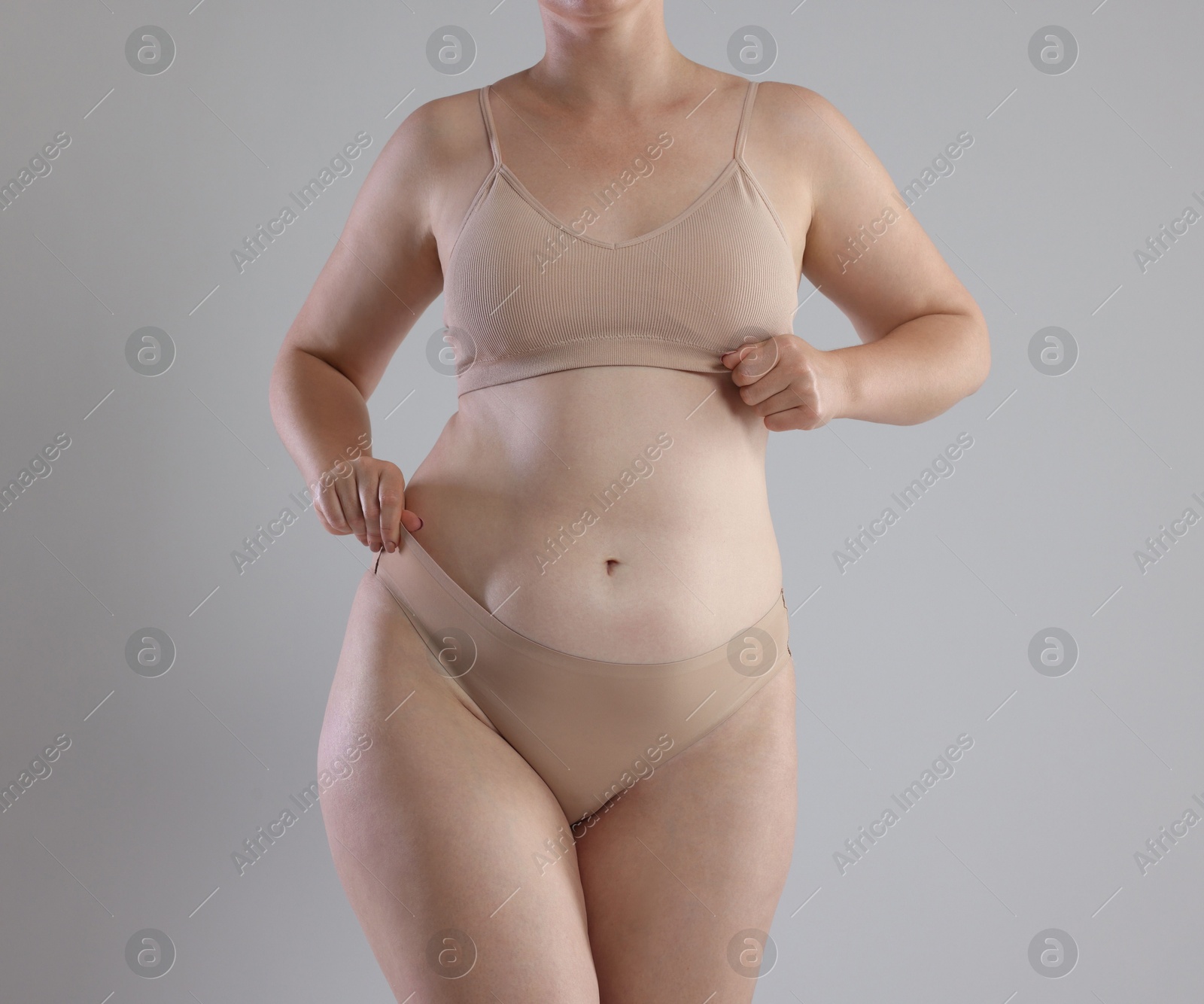 Photo of Liposuction. Woman in underwear on grey background, closeup