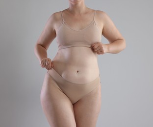 Photo of Liposuction. Woman in underwear on grey background, closeup