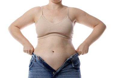 Photo of Liposuction. Woman trying to put on tight jeans against white background, closeup