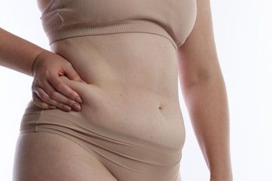 Photo of Liposuction. Woman in underwear touching her belly on white background, closeup