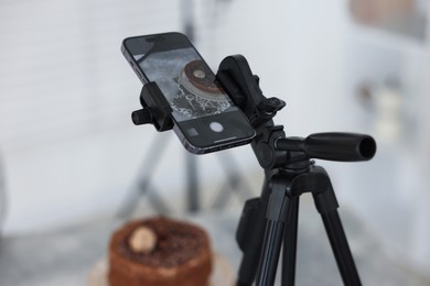 Photo of Shooting chocolate cake with smartphone in studio, selective focus. Professional food photography