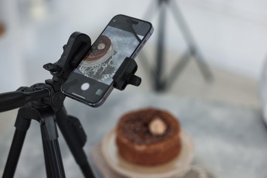 Photo of Shooting chocolate cake with smartphone in studio, selective focus. Professional food photography