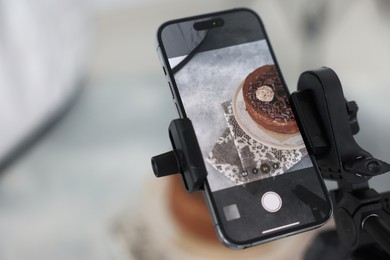 Photo of Shooting chocolate cake with smartphone in studio, selective focus. Professional food photography