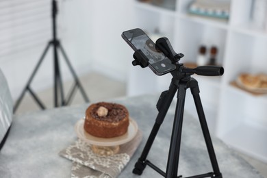 Photo of Shooting chocolate cake with smartphone in studio, selective focus. Professional food photography