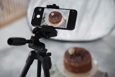 Photo of Shooting chocolate cake with smartphone in studio, selective focus. Professional food photography