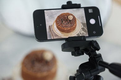 Photo of Shooting chocolate cake with smartphone in studio, selective focus. Professional food photography