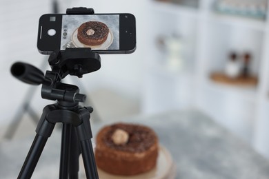 Photo of Shooting chocolate cake with smartphone in studio, selective focus. Professional food photography