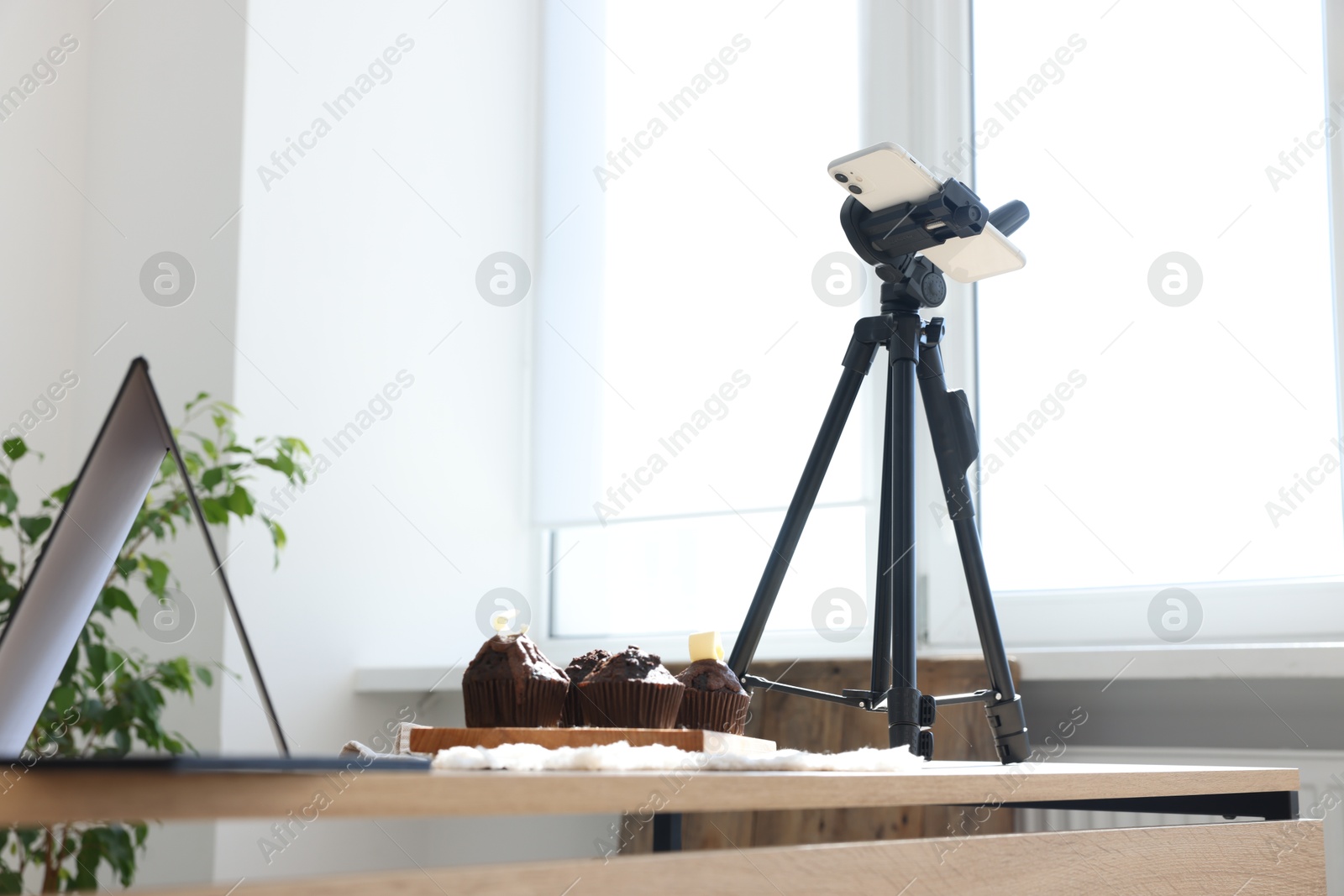 Photo of Shooting chocolate muffins with smartphone in studio. Professional food photography