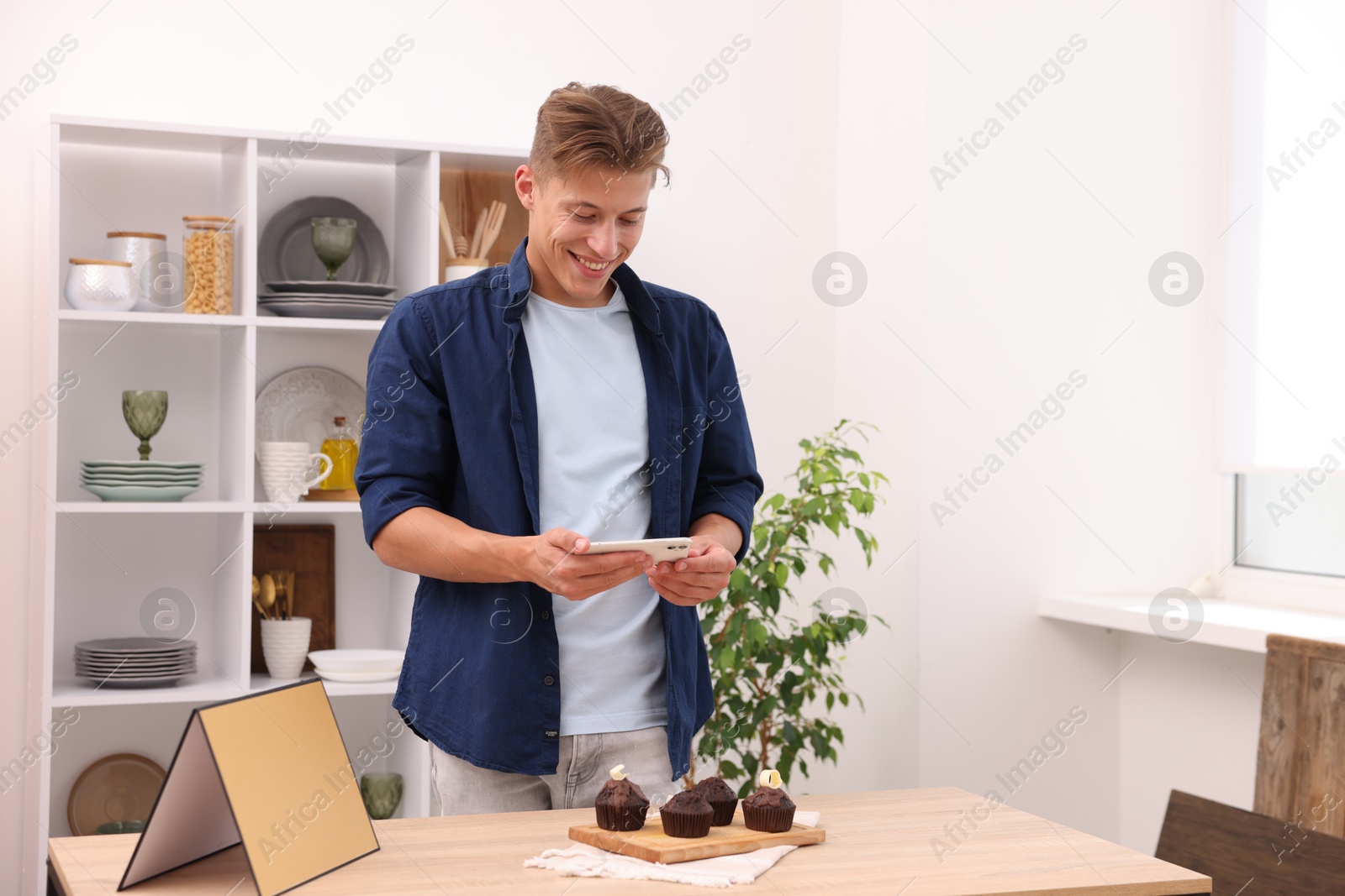Man taking picture of chocolate muffins in studio. Professional food photography Photo of Man taking picture of chocolate muffins in studio. Professional food photography