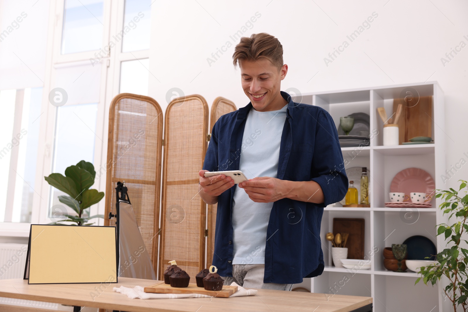 Man taking picture of chocolate muffins in studio. Professional food photography Photo of Man taking picture of chocolate muffins in studio. Professional food photography