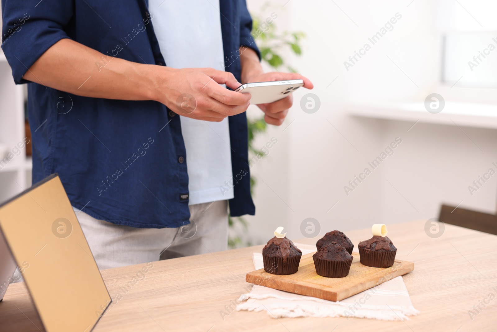 Man taking picture of chocolate muffins in studio, closeup. Professional food photography Photo of Man taking picture of chocolate muffins in studio, closeup. Professional food photography