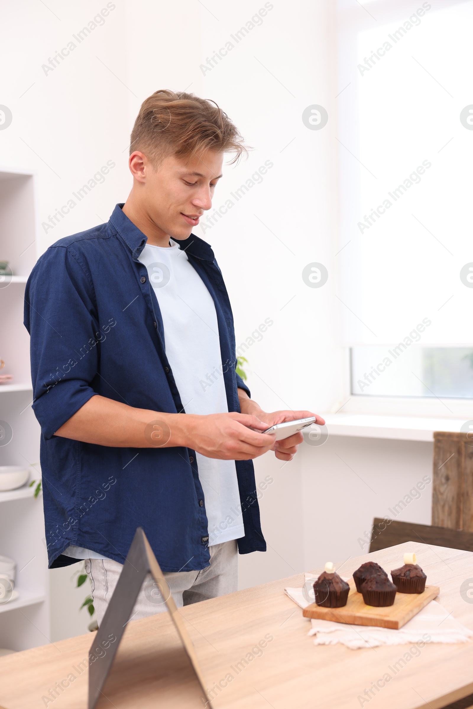 Man taking picture of chocolate muffins in studio. Professional food photography Photo of Man taking picture of chocolate muffins in studio. Professional food photography