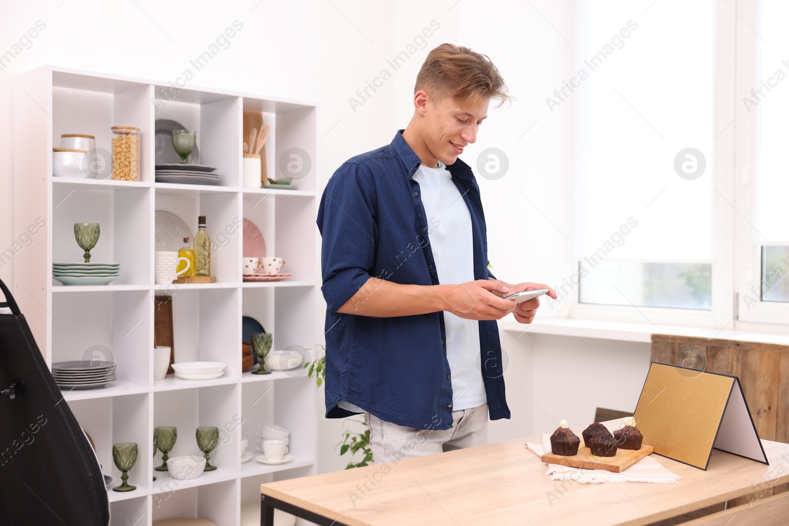 Man taking picture of chocolate muffins in studio. Professional food photography Photo of Man taking picture of chocolate muffins in studio. Professional food photography