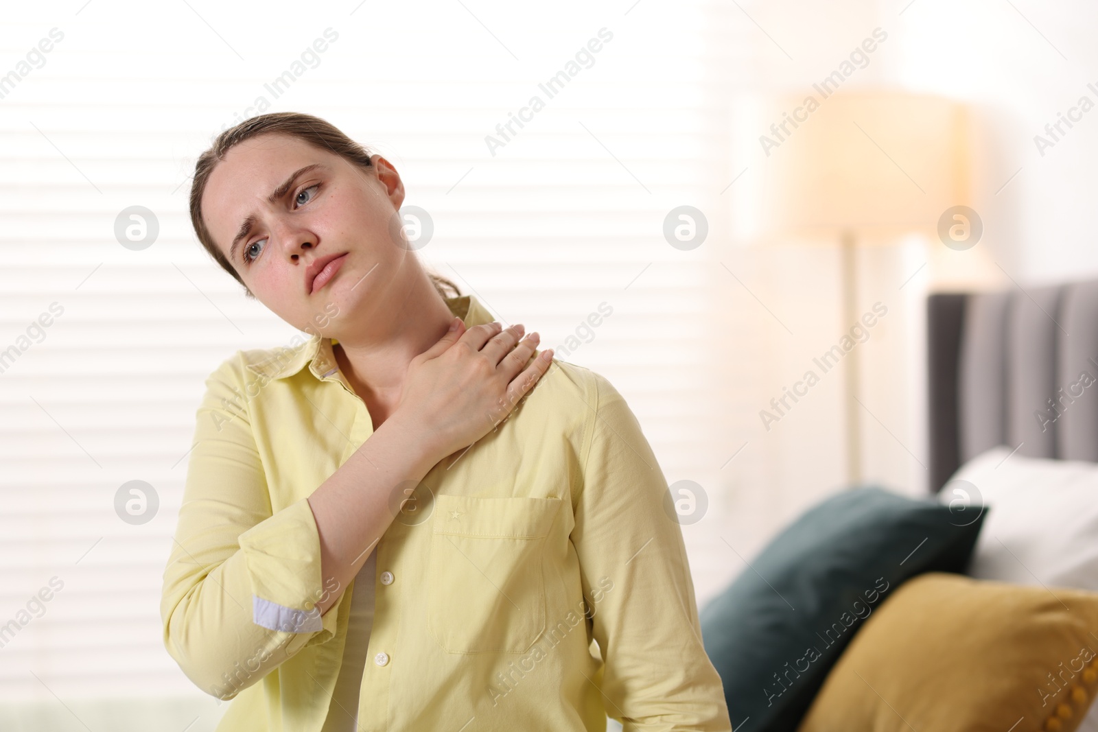 Young woman suffering from neck pain at home Photo of Young woman suffering from neck pain at home