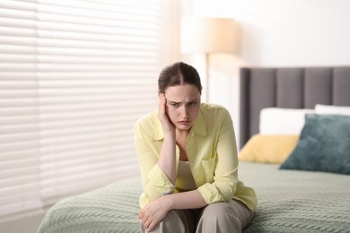 Photo of Young woman suffering from headache at home