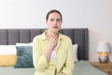 Photo of Young woman suffering from sore throat at home