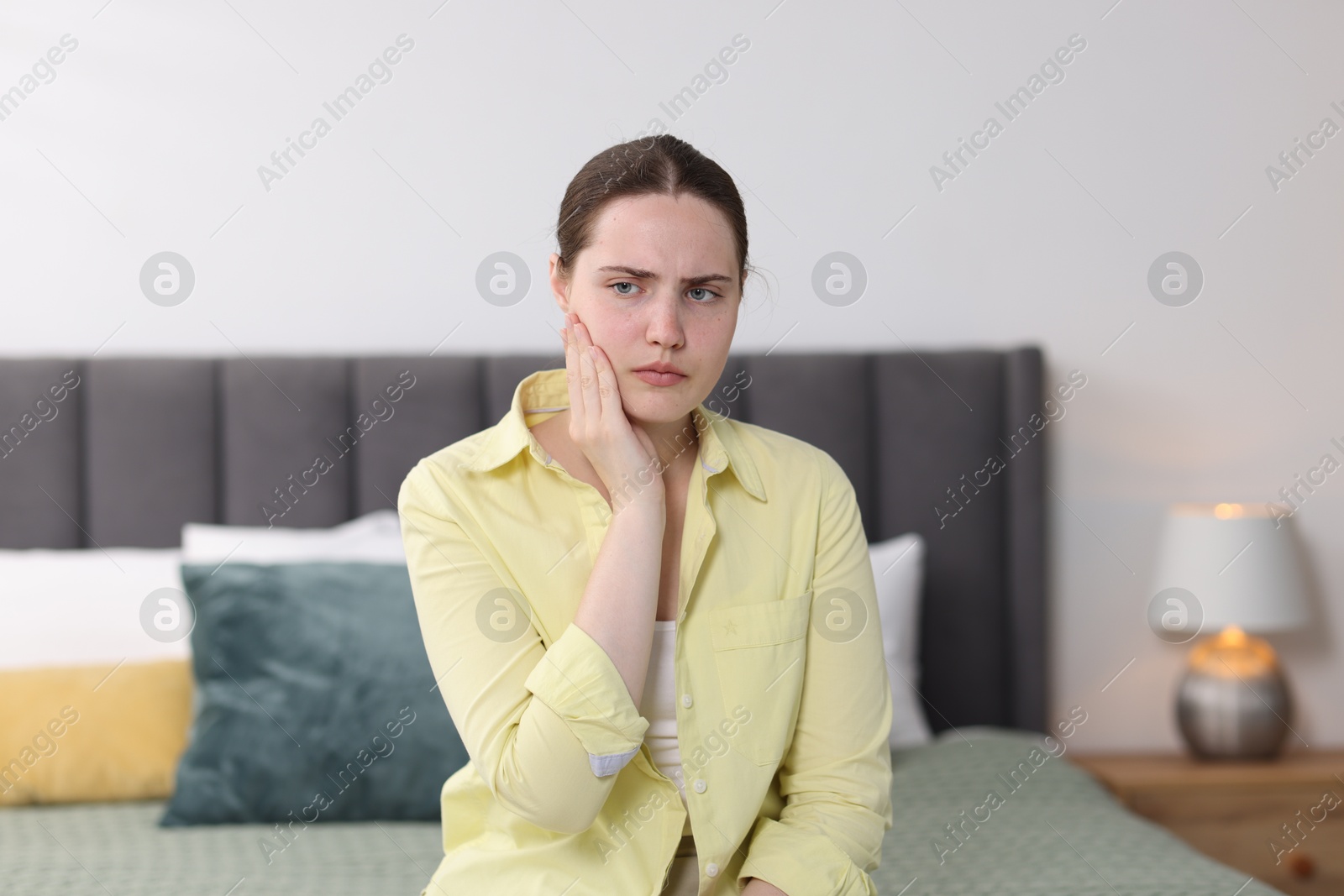 Photo of Young woman suffering from sore throat at home