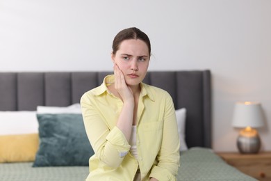 Photo of Young woman suffering from sore throat at home