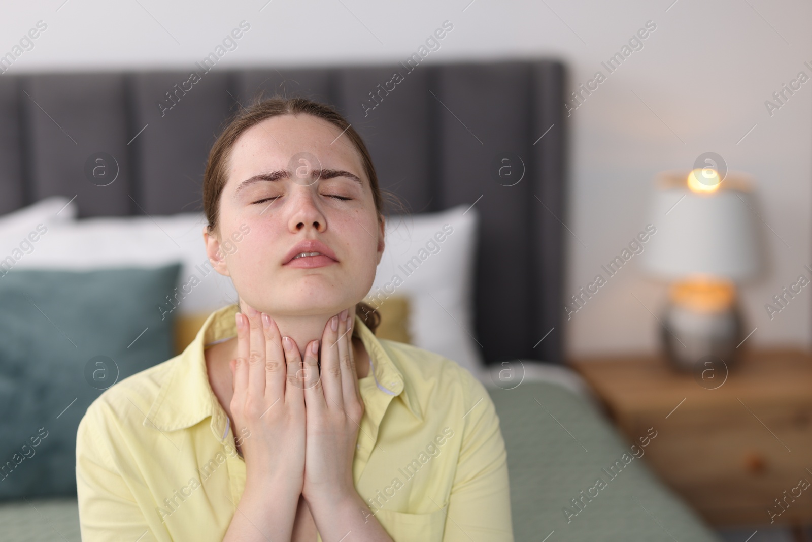 Young woman suffering from sore throat at home, space for text Photo of Young woman suffering from sore throat at home, space for text