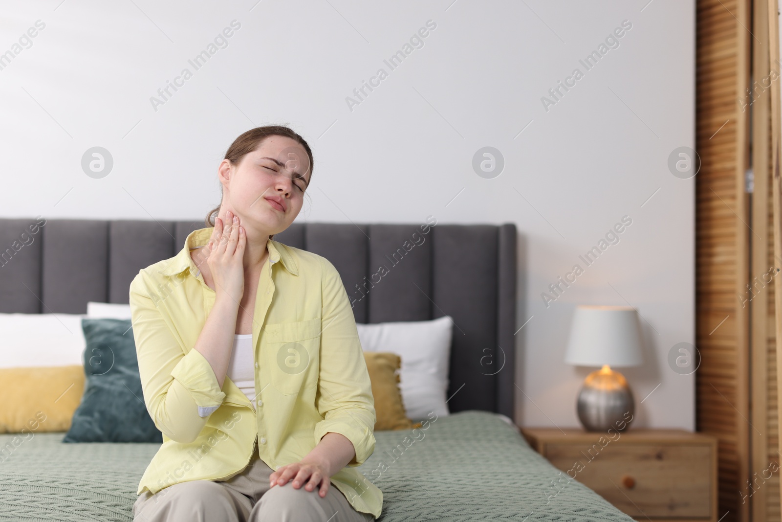 Young woman suffering from sore throat at home, space for text Photo of Young woman suffering from sore throat at home, space for text