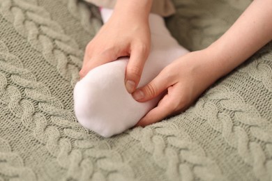 Photo of Young woman suffering from foot pain at home, closeup