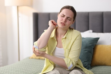 Photo of Young woman suffering from elbow pain at home