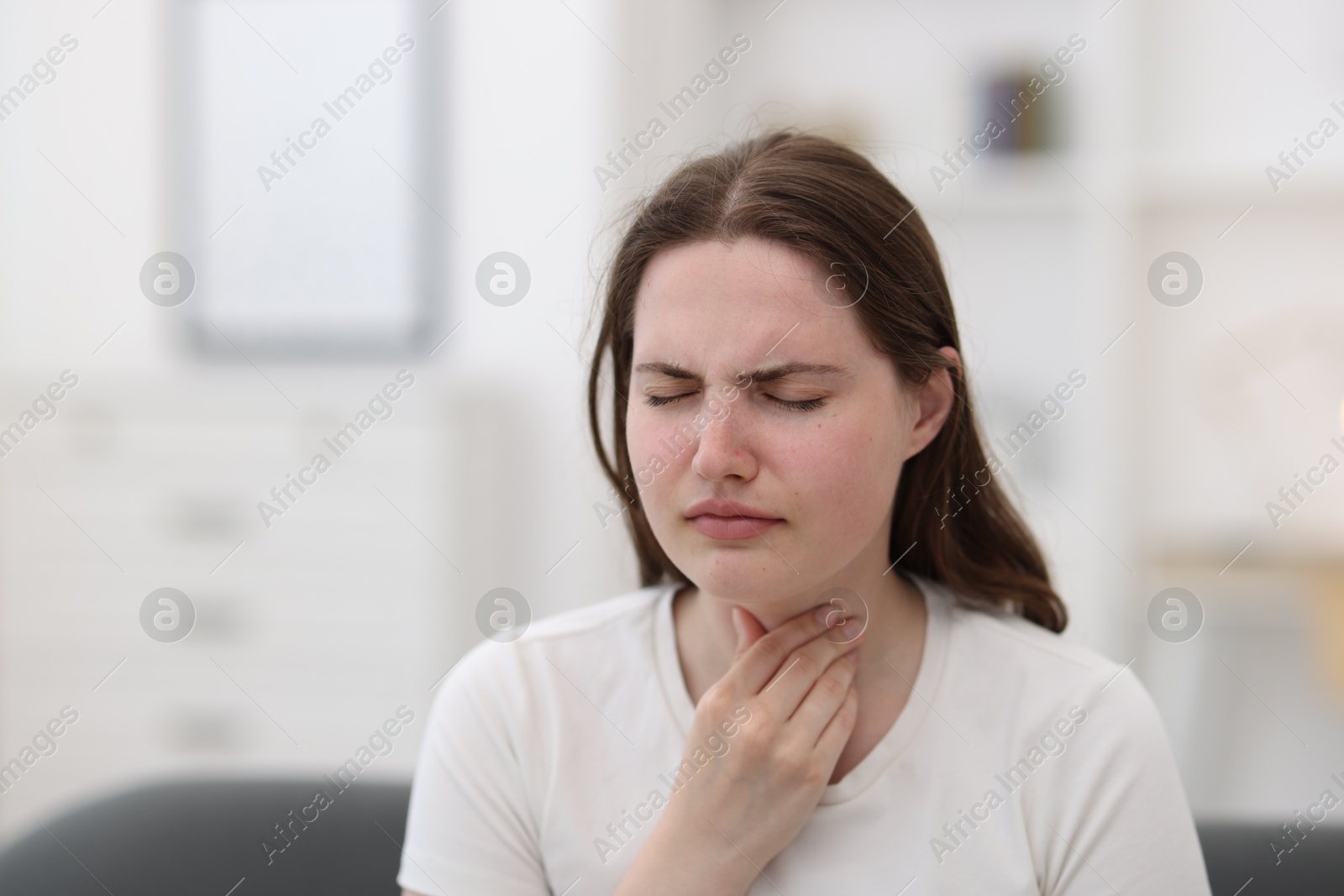 Photo of Young woman suffering from sore throat at home